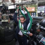 Camacho llega al juzgado con bandera cruceña y fuerte custodia policial